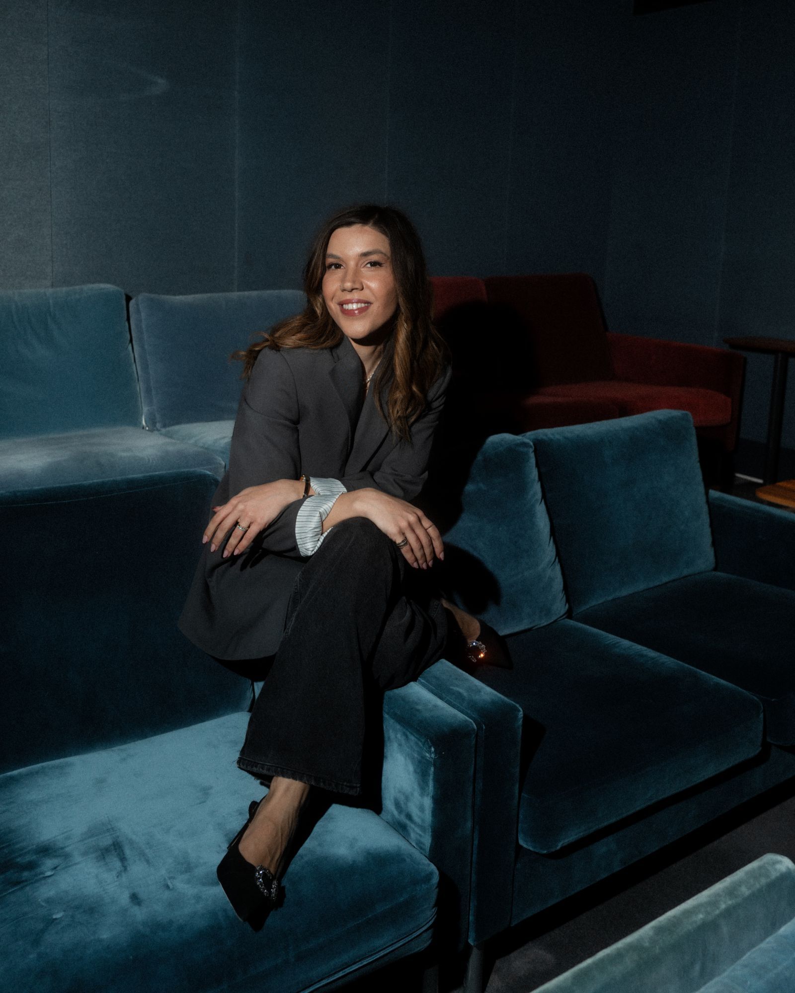 Venice Asourmatzian seated in a cinema of blue velvet chairs